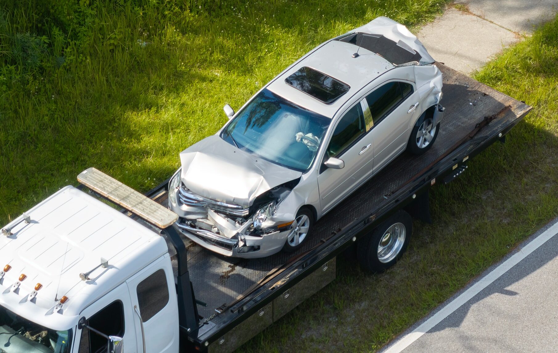 Traffic accident with tow truck hauling smashed vehicle